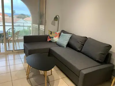 a living room with a gray couch and a stool at Studio Face à la mer in Cervione