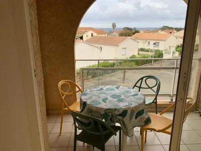 a table and chairs on a balcony with a view at Studio Face à la mer in Cervione