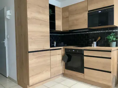 a kitchen with wooden cabinets and a dishwasher at Studio Face à la mer in Cervione