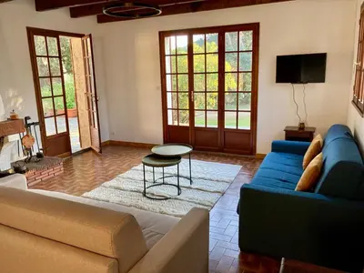a living room with a blue couch and a table at Villa de bord de plage in Pinarellu