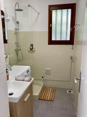 a bathroom with a shower and a sink and a tub at Villa de bord de plage in Pinarellu
