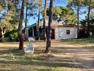 a white chair sitting in front of a house at Villa de bord de plage in Pinarellu