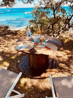 a wooden table with a meal on the beach at Villa de bord de plage in Pinarellu