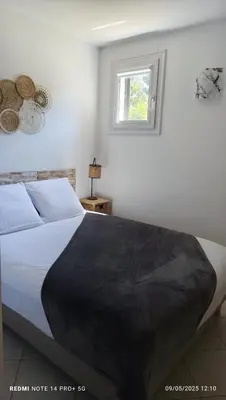 a bedroom with a bed with a black blanket on it at F2 tout confort, les pieds dans l'eau, PORTICCIO in Grosseto-Prugna