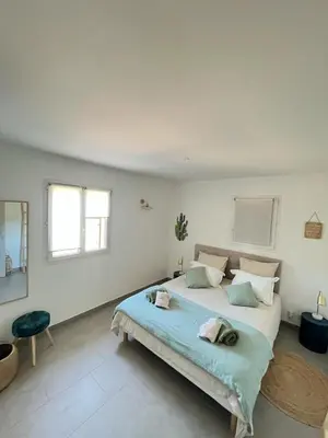 a white bedroom with a large bed in it at Mini villa,, 700 m de la plage à pieds in Pinarellu