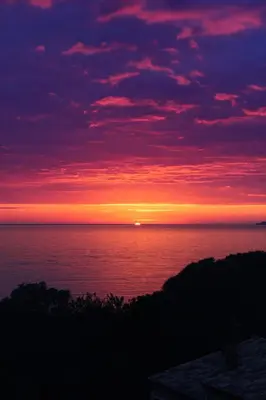 a sunset over the ocean with the sun in the distance at Appartement proche des plages de sable in Grosseto-Prugna