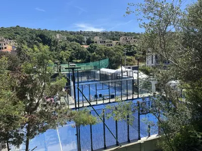 a view of a swimming pool with trees and buildings at Appartement proche des plages de sable in Grosseto-Prugna