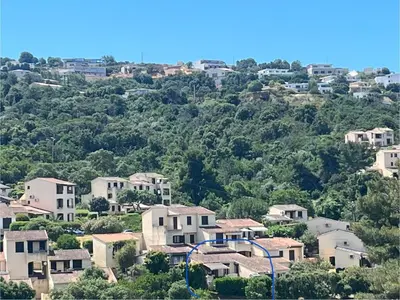 a village on a hill with houses and trees at Appartement proche des plages de sable in Grosseto-Prugna