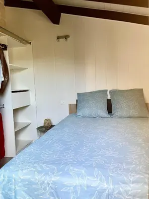 a bedroom with a bed with a blue comforter at Appartement proche des plages de sable in Grosseto-Prugna