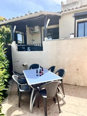 a white table and chairs on a patio at Appartement proche des plages de sable in Grosseto-Prugna