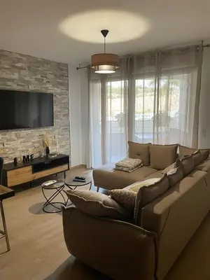 a living room with a couch and a flat screen tv at Appartement T3, 5 minutes à pied des plages in Ajaccio