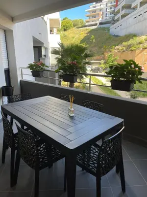 a black table and chairs on a balcony at Appartement T3, 5 minutes à pied des plages in Ajaccio