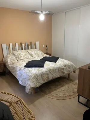 a bedroom with a bed with a comforter on it at Appartement T3, 5 minutes à pied des plages in Ajaccio