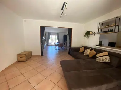 a living room with a brown couch and a table at villa a calata in Porto-Vecchio