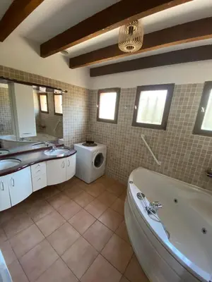 a bathroom with a tub and a sink and a washing machine at villa a calata in Porto-Vecchio