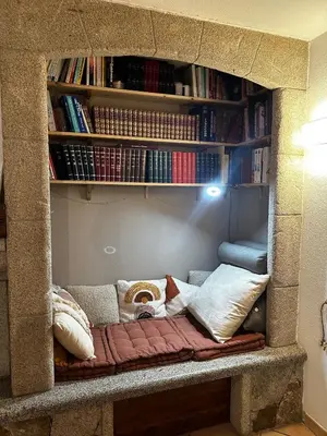 a couch in a room with a book shelf at villa a calata in Porto-Vecchio