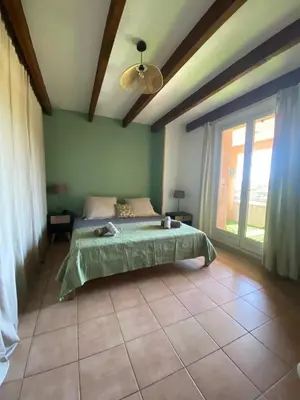 a bedroom with a bed and a large window at villa a calata in Porto-Vecchio