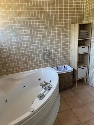 a bath tub in a bathroom with a tiled wall at villa a calata in Porto-Vecchio
