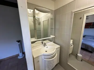 a white bathroom with a sink and a mirror at villa a calata in Porto-Vecchio