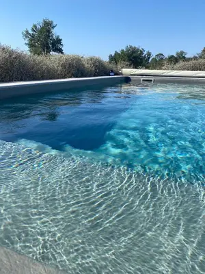 a swimming pool filled with blue water at villa a calata in Porto-Vecchio