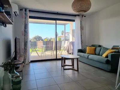 a living room with a couch and a table at Porticcio grand appartement 3 pièces, 5 minutes de la plage in Porticcio
