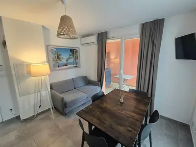 a living room with a table and a couch at Charmant T2 climatisé avec terrasse à 5min des plages in Lecci