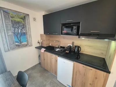 a kitchen with a sink and a microwave at Charmant T2 climatisé avec terrasse à 5min des plages in Lecci