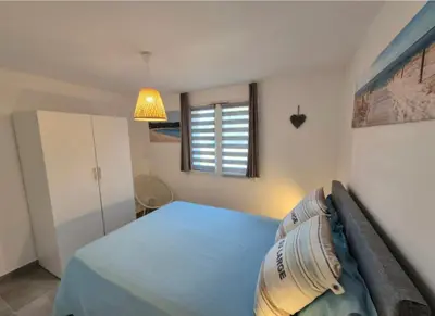 a bedroom with a blue bed and a window at Charmant T2 climatisé avec terrasse à 5min des plages in Lecci