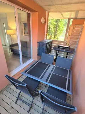 a room with a table and chairs on a deck at Charmant T2 climatisé avec terrasse à 5min des plages in Lecci