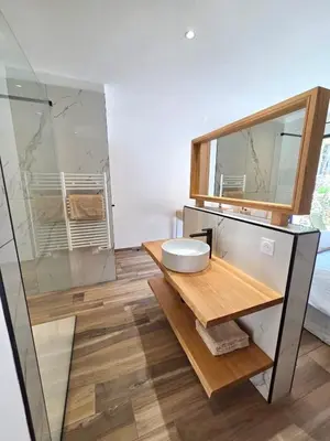 a bedroom with a bed and a glass shower at Maison Mahana in Bonifacio