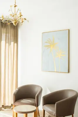 a living room with two chairs and a chandelier at Hotel Arena le Refuge in Corte