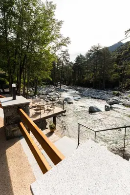 a group of benches sitting next to a river at Hotel Arena le Refuge in Corte