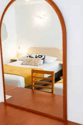 a bedroom with a bed and a mirror at Hotel Arena le Refuge in Corte
