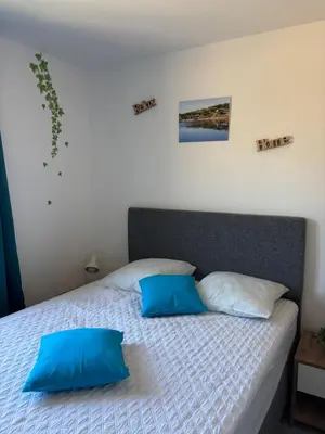a bedroom with a bed with two blue pillows at Alizo in Lecci