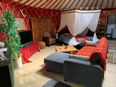 a living room with a tent with a couch and a tv at yourte de luxe contemporaine in Bonifacio