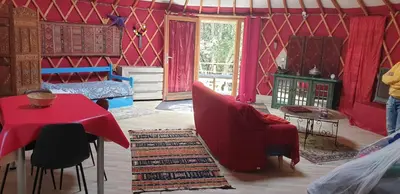 a bedroom with a red room with a bed and a table at yourte de luxe contemporaine in Bonifacio