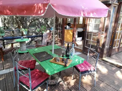 a table and chairs under an umbrella on a deck at yourte de luxe contemporaine in Bonifacio