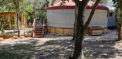 a large white and red building with a tree at yourte de luxe contemporaine in Bonifacio