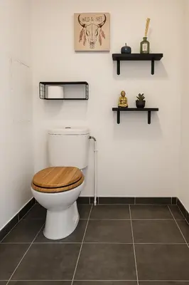 a bathroom with a toilet with a wooden toilet seat at APPARTEMENT T3 65 m2 CENTRE VILLE in Porto-Vecchio