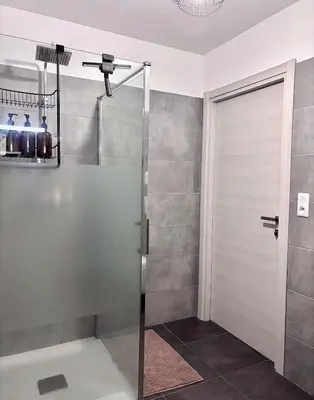 a shower with a glass door in a bathroom at Charmant t2 avec terrasse in Corte
