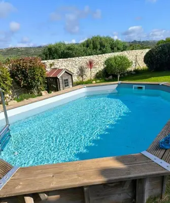 a large swimming pool with a bench and a house at Casa EliaEmie Bonifacio in Bonifacio
