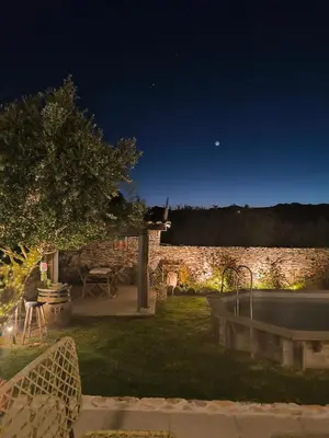 a backyard at night with a stone wall at Casa EliaEmie Bonifacio in Bonifacio
