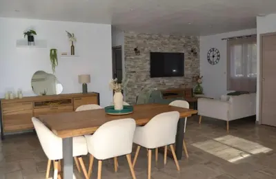 a living room with a wooden table and white chairs at Casa EliaEmie Bonifacio in Bonifacio