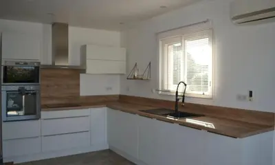 a kitchen with white cabinets and a sink and a window at Casa EliaEmie Bonifacio in Bonifacio