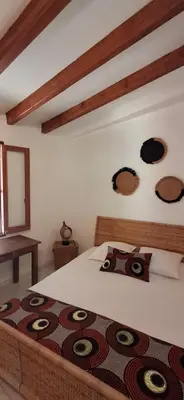 a bedroom with a large bed with a blanket at Maison Authentique Corse Vue Mer Panoramique et Nature Sauvage in Zonza