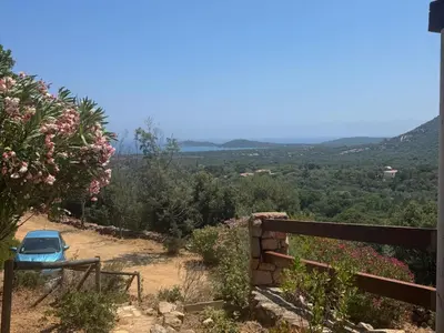 a blue car parked on the side of a hill at Maison Authentique Corse Vue Mer Panoramique et Nature Sauvage in Zonza