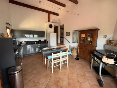 a kitchen and dining room with a table and chairs at Maison Authentique Corse Vue Mer Panoramique et Nature Sauvage in Zonza