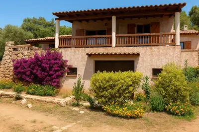 a house with a balcony on top of it at Maison Authentique Corse Vue Mer Panoramique et Nature Sauvage in Zonza