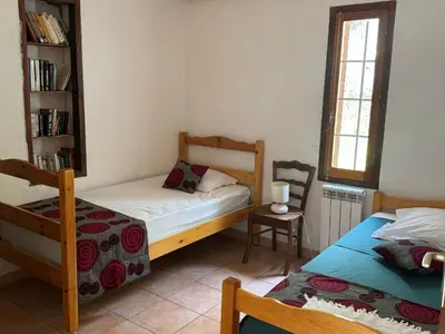 a bedroom with two beds and a book shelf at Maison Authentique Corse Vue Mer Panoramique et Nature Sauvage in Zonza