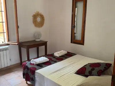 a bedroom with two beds and a mirror at Maison Authentique Corse Vue Mer Panoramique et Nature Sauvage in Zonza